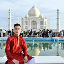 a man sitting in front of the taj mahal
