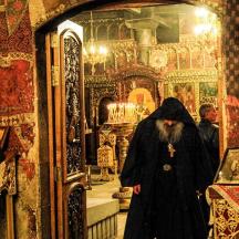 a woman in a black coat walking through a room