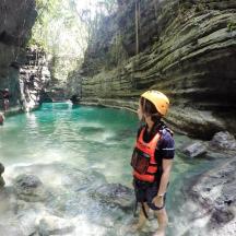 a man standing in a pool of water in a cave