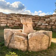 a stone statue in front of a stone wall