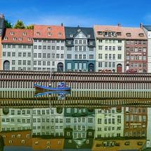 a reflection of a building in the water with a boat