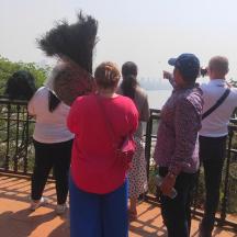 a group of people standing on a balcony looking at the water