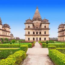 a view of a palace with a garden and bushes