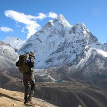 a man with a backpack standing on top of a mountain