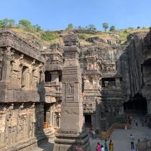 a group of people walking around a large stone building