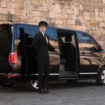 a man in a suit standing next to a van