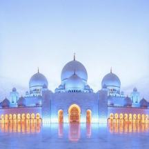 a mosque with domes and minarets at dusk