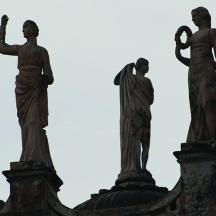 drei Statuen von Menschen auf einem Gebäude