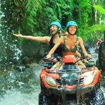 two people riding on a four wheeler through a river