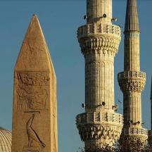 a group of three minarelled mosques and a pyramid