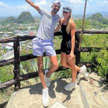a man and a woman standing on top of a mountain