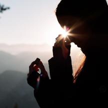a woman standing in front of the sunset