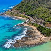 an aerial view of the ocean and a road