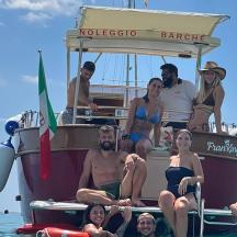 a group of people sitting on the back of a boat