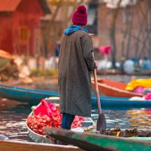 a woman is standing on a boat with a paddle
