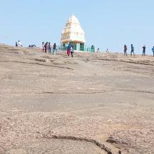 people walking on the beach with a temple in the background