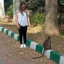a woman standing next to a cat on a curb
