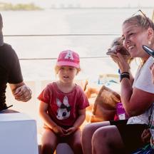 un grup de persones assegudes al costat d'una dona