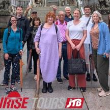 a group of people posing for a picture in front of a building