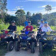 un grup de persones assegudes en quads en un camí de terra