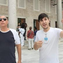 two men standing in front of a building giving the finger