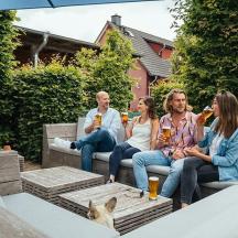 eine Gruppe von Menschen sitzt mit einem Hund auf einer Bank