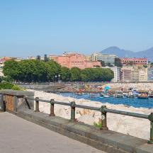 a beach with boats in the water and a city
