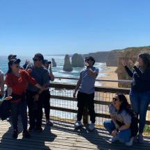 a group of people walking on the great ocean road