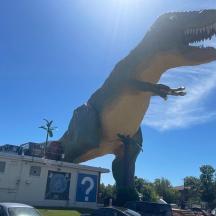 patung dinosaur berdiri di tempat letak kereta