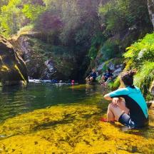 un grup de persones assegudes a l'aigua d'un riu