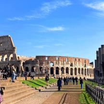 a group of people walking around the coliseum