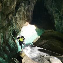 un home està dret sobre una corda en una cova