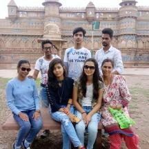 a group of people sitting on a bench in front of a building