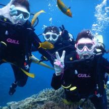 a group of people in the ocean with fish
