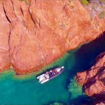 una barca in uno specchio d'acqua vicino a una scogliera