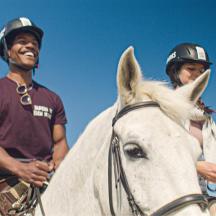 a man and a woman riding on a white horse