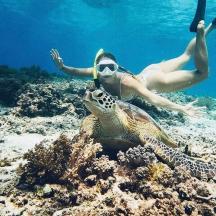 a woman and a turtle in the ocean
