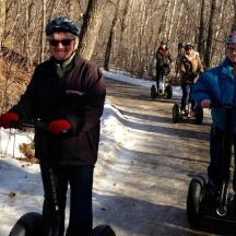 un grup de persones que van amb segways per una carretera