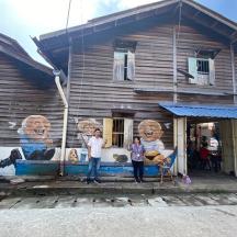 two children standing in front of a wooden house