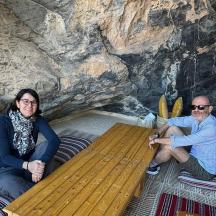 two people sitting on a bench in a cave