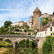 a bridge over a river in front of a castle