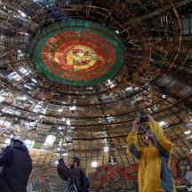 a group of people taking pictures of a large ceiling
