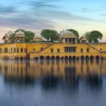 a large yellow building in the middle of a lake