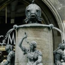a statue of two women and a fountain in front of a building