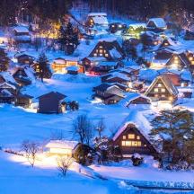 ein Dorf, das nachts mit Schnee bedeckt ist