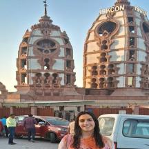 a woman standing in a parking lot in front of a building