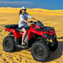 a woman riding a quad bike in the desert