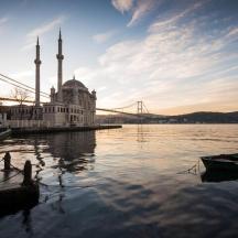 a building on the water with a bridge and a boat