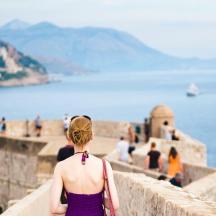 a woman standing on a wall looking at the water