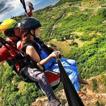 ein Mann und eine Frau auf einer Seilrutsche über einem Berg